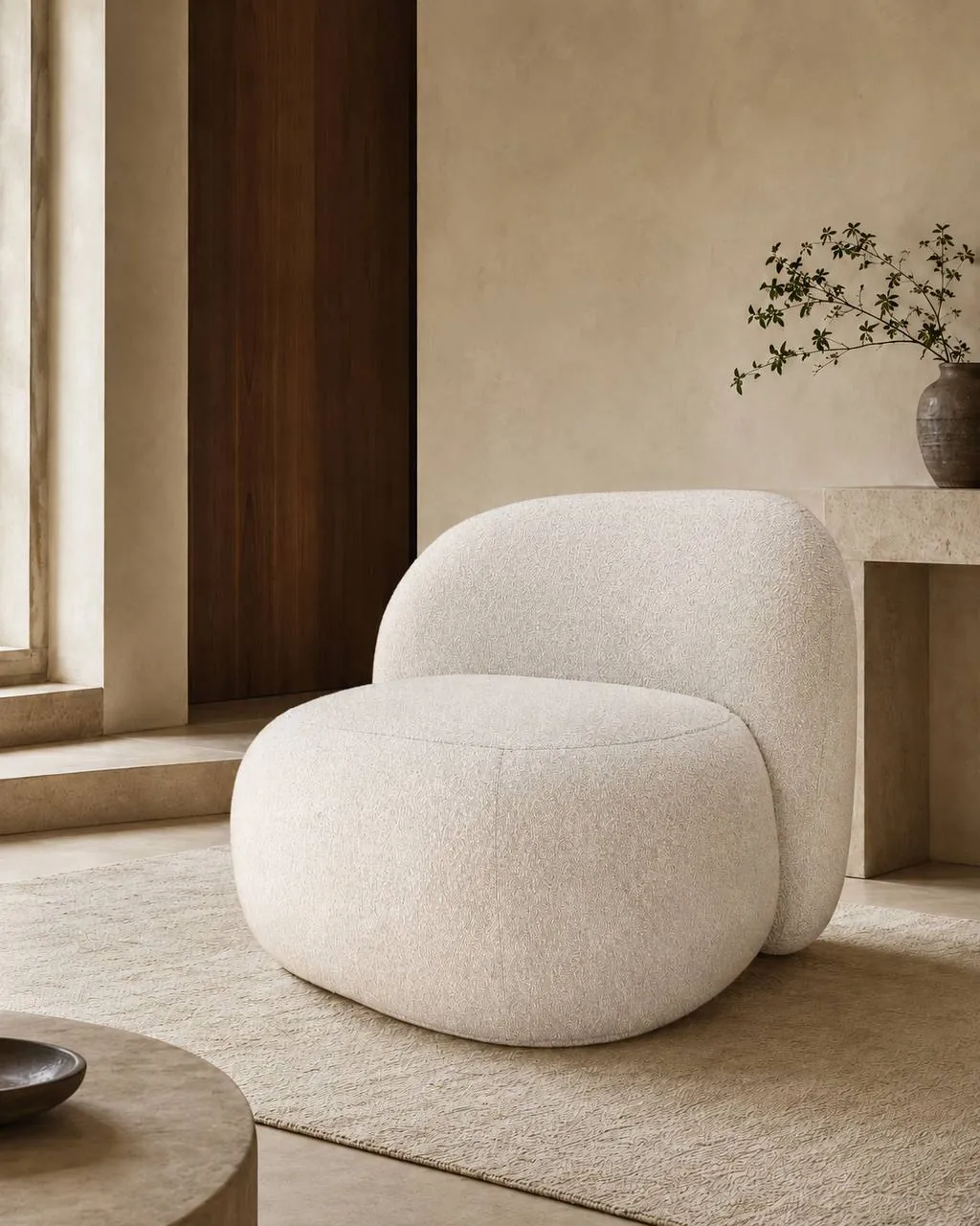 Ivory sculptural upholstered lounge chair with a rounded seat and back in a styled interior visualization.